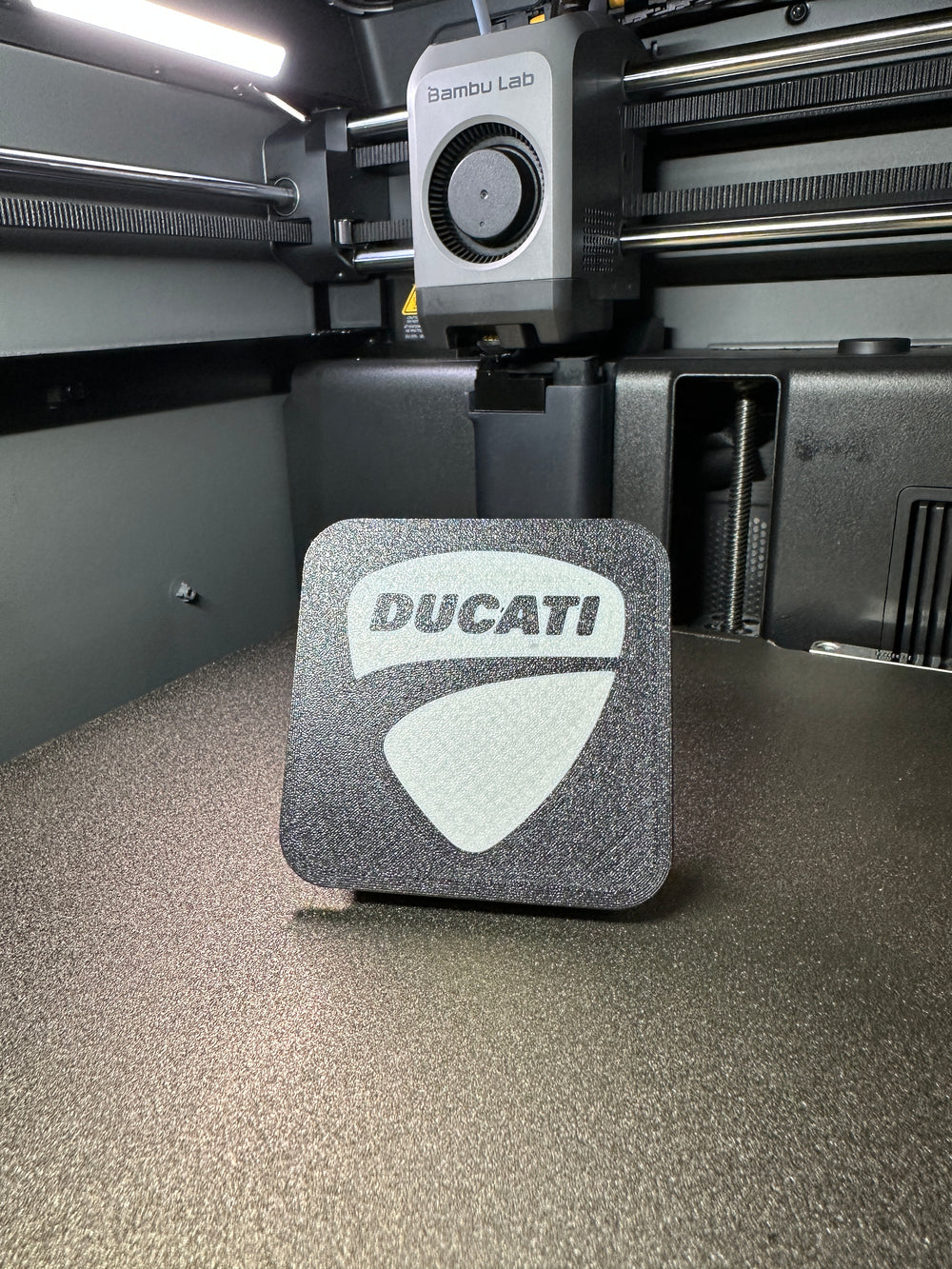 Tapa decorativa con logo Ducati impresa en 3D para el soporte antirrobo