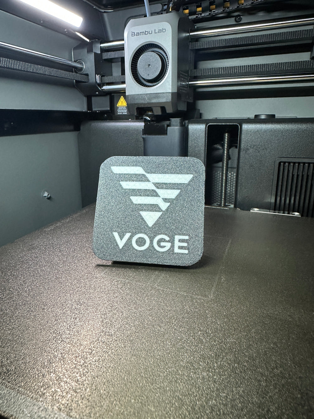Tapa decorativa con logo Voge impresa en 3D para el soporte antirrobo