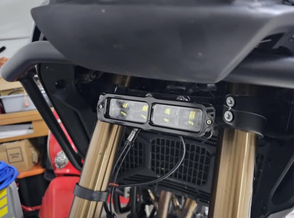 Barra LED instalada en las horquillas de una CFMoto 450MT, vista diurna